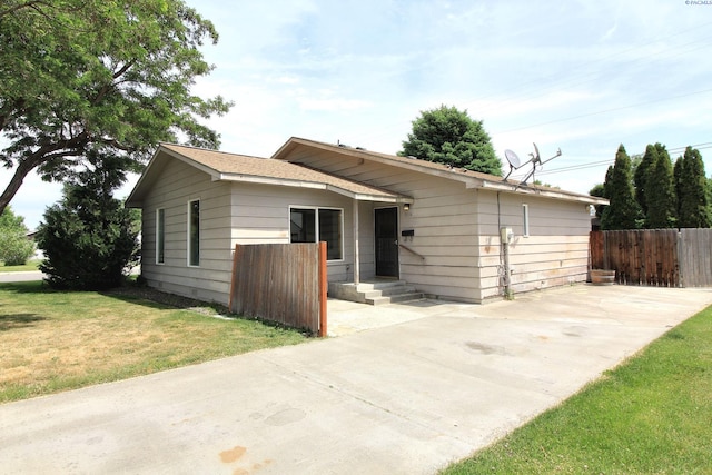 view of front of home with fence and a front lawn