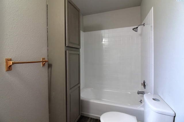 bathroom featuring washtub / shower combination and toilet