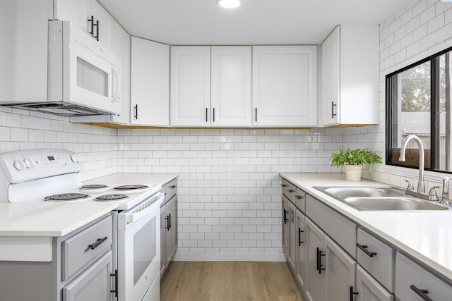 1517 Perkins Ave, Richland, WA 99354 - kitchen with white appliances, light wood-style floors, a sink, light countertops, and white cabinets
