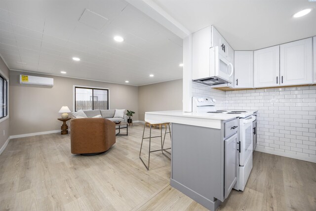 1517 Perkins Ave, Richland, WA 99354 - kitchen with white range with electric stovetop, an AC wall unit, light wood-style flooring, white cabinets, and light countertops