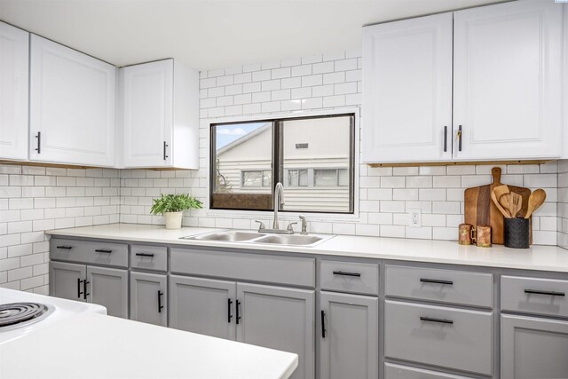 1517 Perkins Ave, Richland, WA 99354 - kitchen with a sink, gray cabinetry, light countertops, backsplash, and white cabinets