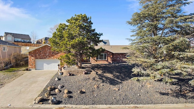 view of front of home with concrete driveway, brick siding, and an attached garage