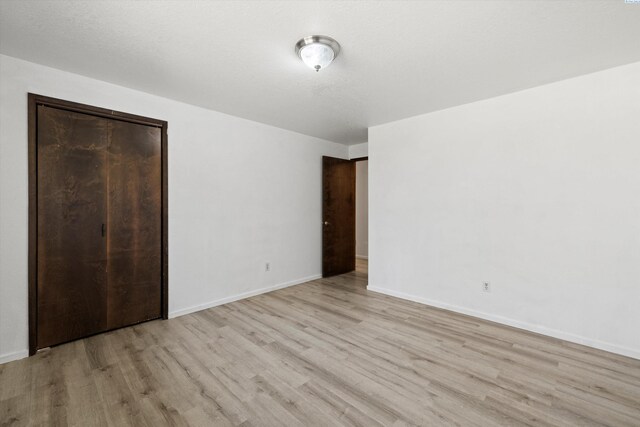 unfurnished bedroom featuring wood finished floors and baseboards