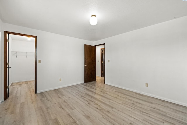 empty room with light wood finished floors and baseboards