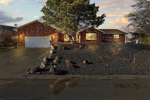 ranch-style home with a garage, driveway, and brick siding