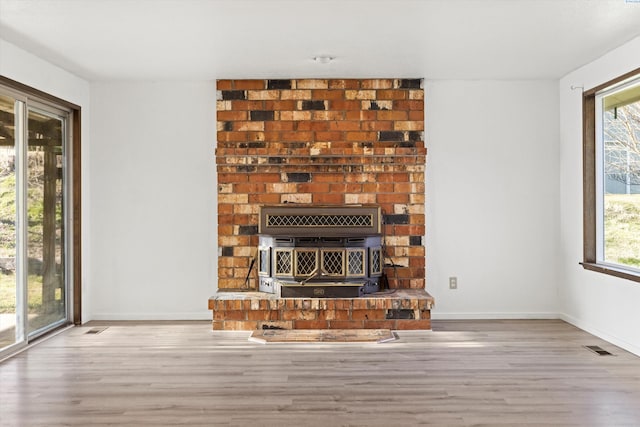 unfurnished living room featuring baseboards, visible vents, and wood finished floors