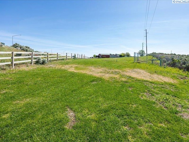 view of yard featuring fence and a rural view