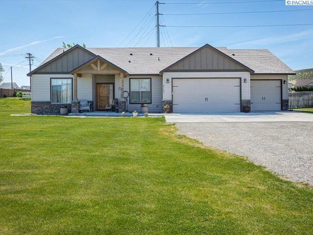 82647 E Reata Rd, Kennewick, WA 99338 - view of front of home with board and batten siding, driveway, a garage, and a front yard