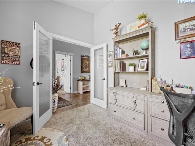home office with french doors and light carpet