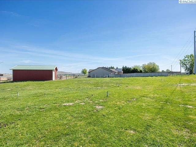 view of yard with fence, an outbuilding, and an outdoor structure