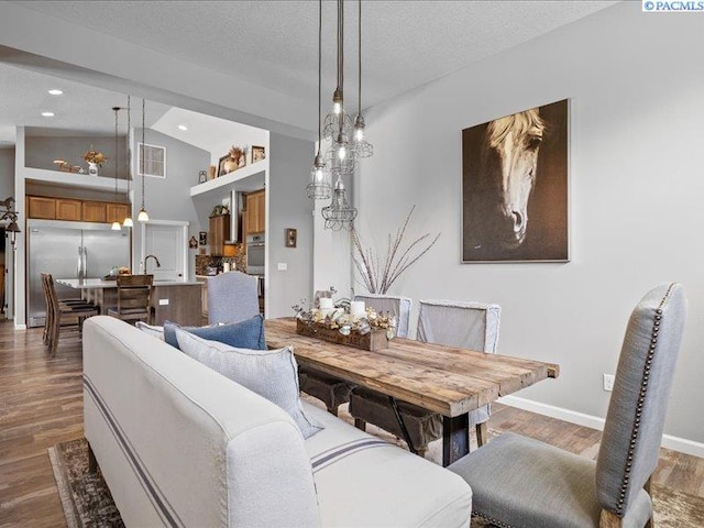 dining space with recessed lighting, baseboards, wood finished floors, lofted ceiling, and visible vents