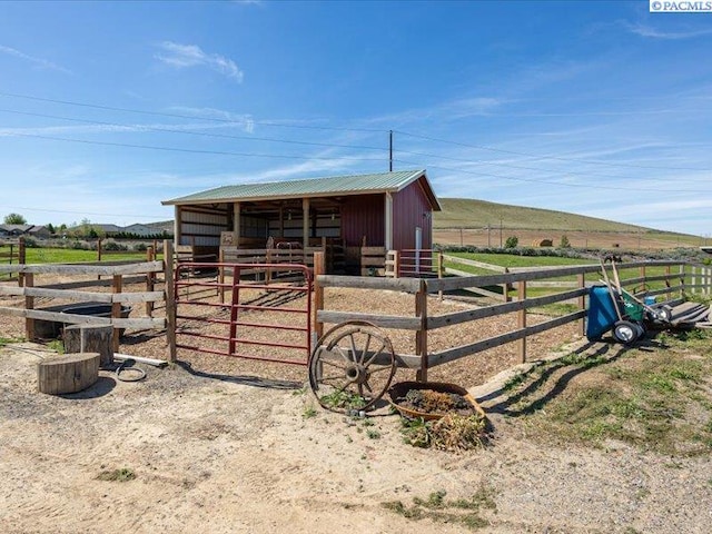 view of outbuilding with an exterior structure, a rural view, and an outdoor structure