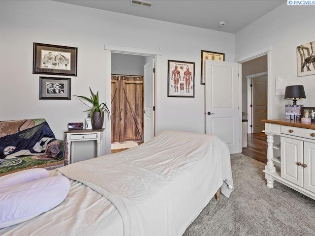 bedroom featuring visible vents and light colored carpet