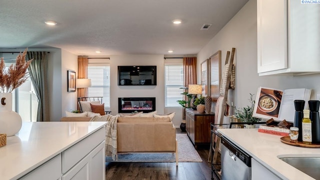 611 S Zeelar St, Kennewick, WA 99336 - living area with dark wood finished floors, plenty of natural light, a glass covered fireplace, and recessed lighting