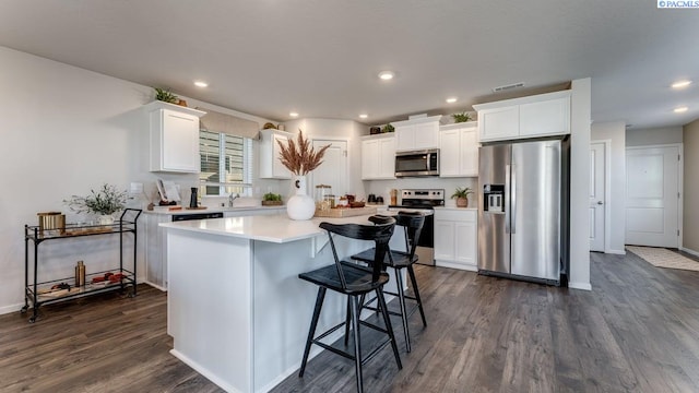 611 S Zeelar St, Kennewick, WA 99336 - kitchen featuring appliances with stainless steel finishes, dark wood-style flooring, white cabinetry, a kitchen island, and recessed lighting