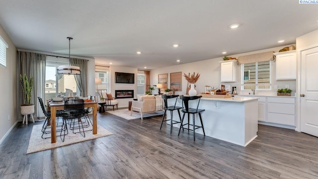 611 S Zeelar St, Kennewick, WA 99336 - kitchen with a kitchen bar, dark wood-style flooring, plenty of natural light, white cabinetry, and recessed lighting