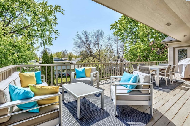 wooden terrace with outdoor dining area, a grill, and an outdoor living space
