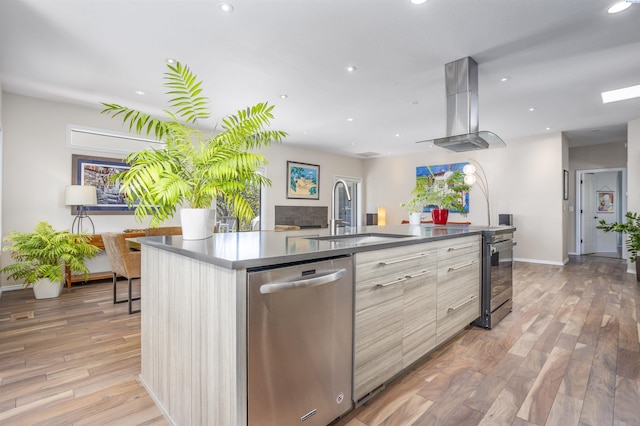 kitchen featuring a sink, extractor fan, a large island with sink, dishwasher, and modern cabinets