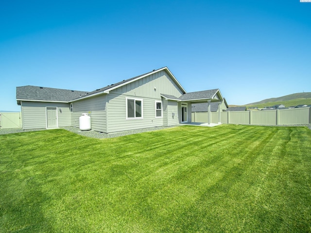 1580 SW Kelandren Dr, Prosser, WA 99350 - rear view of property with board and batten siding, fence, and a yard