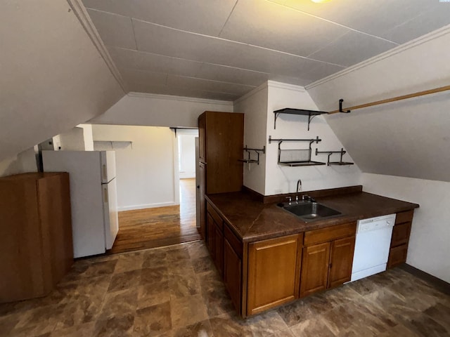 320 SE High St, Pullman, WA 99163 - kitchen with vaulted ceiling, a sink, brown cabinetry, white appliances, and dark countertops