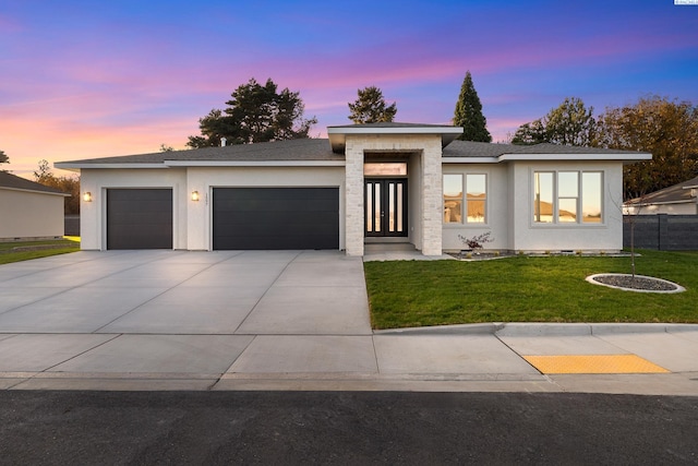 prairie-style house with a garage and a yard