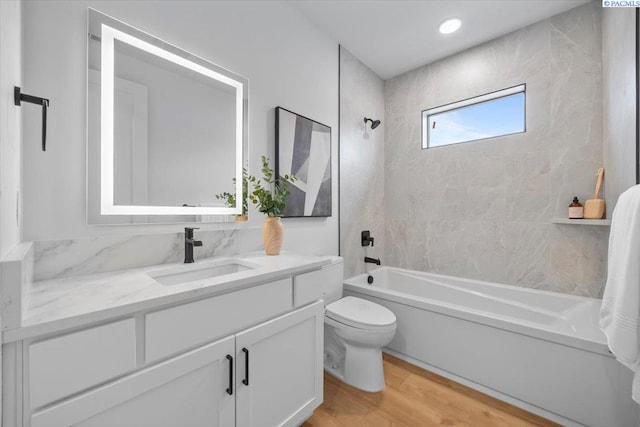 full bathroom with vanity, toilet, tiled shower / bath combo, and wood-type flooring