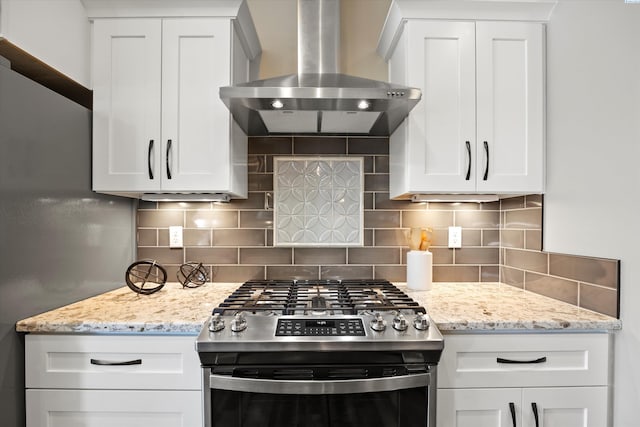 1120 S Kansas Pl, Kennewick, WA 99338 - kitchen featuring decorative backsplash, stainless steel gas stove, wall chimney range hood, white cabinets, and light stone counters