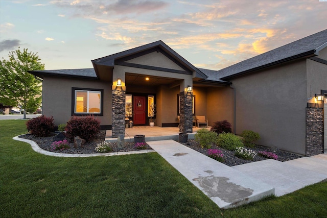 1120 S Kansas Pl, Kennewick, WA 99338 - view of front of house featuring a yard, stone siding, a porch, and stucco siding