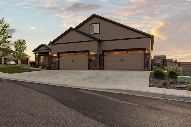 1120 S Kansas Pl, Kennewick, WA 99338 - view of front facade with stucco siding, an attached garage, driveway, and stone siding