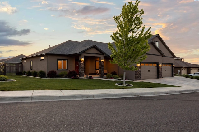 1120 S Kansas Pl, Kennewick, WA 99338 - view of front facade featuring concrete driveway, a lawn, stone siding, and stucco siding