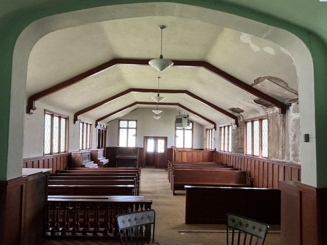 misc room featuring lofted ceiling and wooden walls