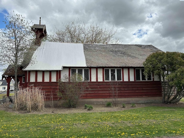 view of side of property with a lawn