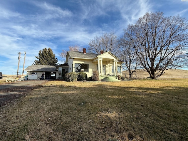 view of front facade featuring a chimney and a front lawn