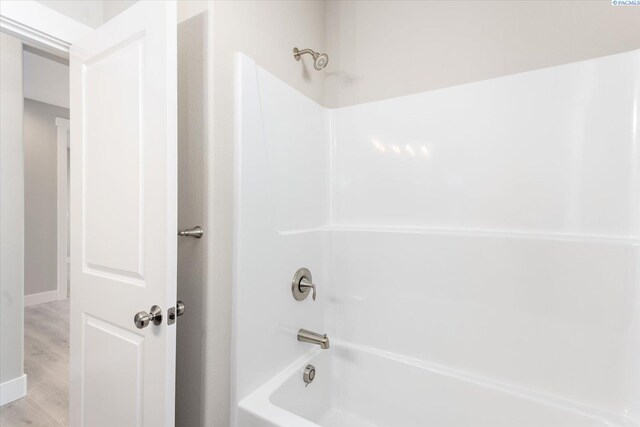 bathroom with hardwood / wood-style flooring and  shower combination