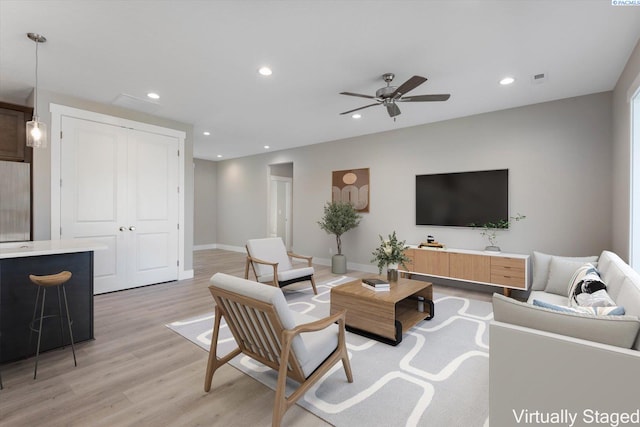 living room with ceiling fan and light hardwood / wood-style flooring