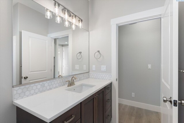 bathroom with vanity, decorative backsplash, and hardwood / wood-style flooring