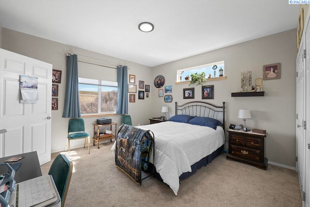 bedroom with baseboards and light colored carpet