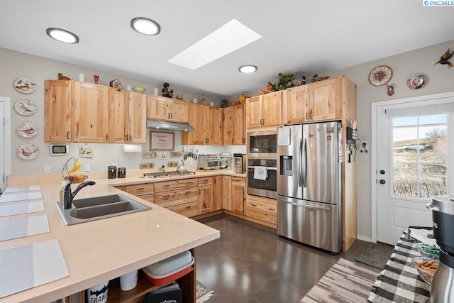 kitchen with light brown cabinets, stainless steel appliances, a sink, and under cabinet range hood