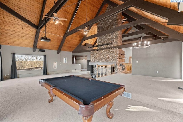 playroom with visible vents, wooden ceiling, a stone fireplace, carpet floors, and beam ceiling