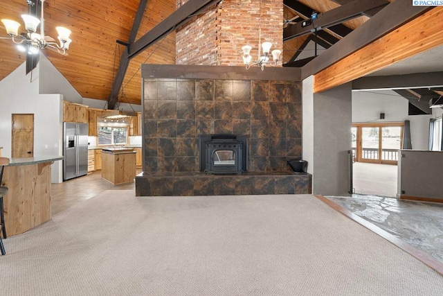 unfurnished living room featuring light carpet, an inviting chandelier, and beam ceiling