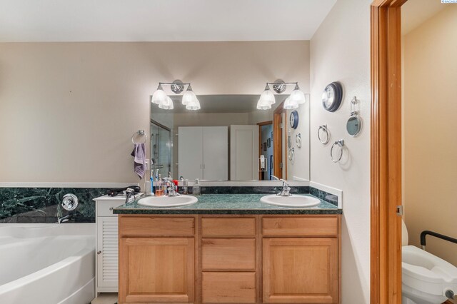 704 W 18th Ct, Kennewick, WA 99337 - full bathroom with double vanity, a bath, a shower stall, and toilet