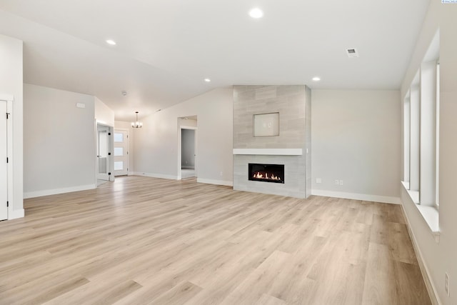 10709 Kokanee Dr, Pasco, WA 99301 - unfurnished living room featuring vaulted ceiling, light wood-type flooring, a fireplace, and recessed lighting