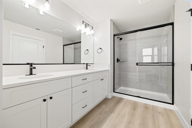 10709 Kokanee Dr, Pasco, WA 99301 - full bath with double vanity, a shower with door, and wood finished floors