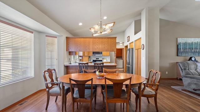 4318 Desert Pl, Pasco, WA 99301 - dining area with a chandelier, light wood finished floors, and high vaulted ceiling