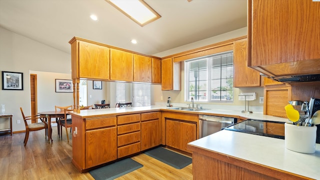 4318 Desert Pl, Pasco, WA 99301 - kitchen with a peninsula, dishwasher, vaulted ceiling, light countertops, and light wood-style floors