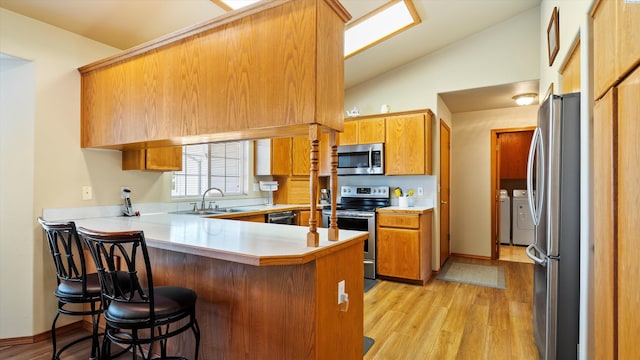 4318 Desert Pl, Pasco, WA 99301 - kitchen with stainless steel appliances, a peninsula, light countertops, light wood-style flooring, and brown cabinets