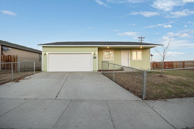 single story home featuring driveway, a fenced front yard, and an attached garage