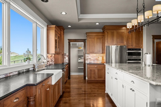 805 W Summit Rd, Colfax, WA 99111 - kitchen with stainless steel appliances, brown cabinetry, backsplash, crown molding, and dark wood finished floors
