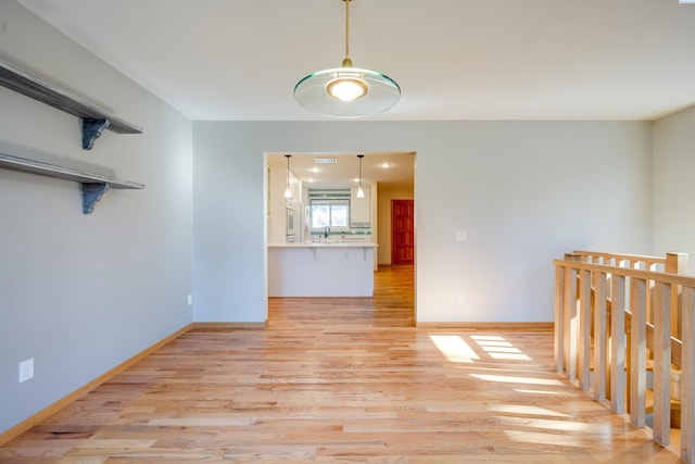 empty room featuring light wood-type flooring and baseboards