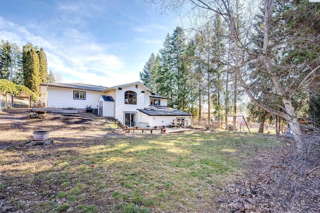 rear view of house featuring a patio, a lawn, and fence